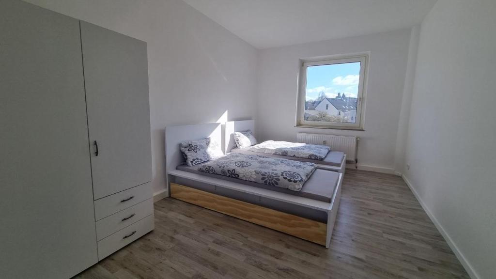 um quarto com uma cama e uma janela em Moderne Wohnung mit Gartenzugang em Essen