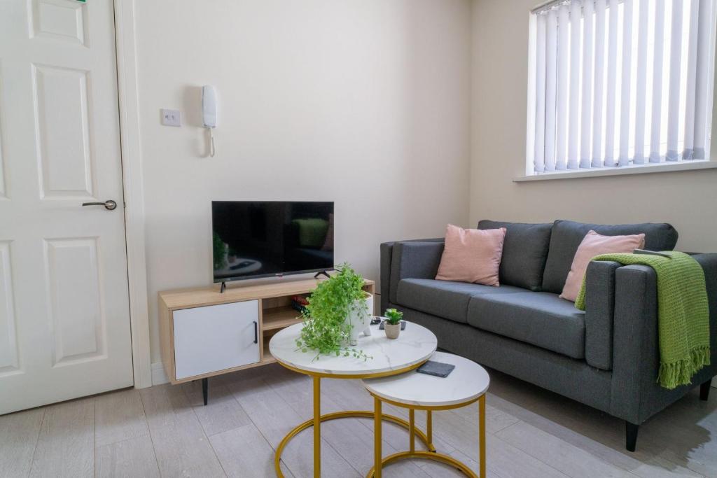 a living room with a couch and a tv at Cohost Partners | Free Parking | Free Wifi in Newport
