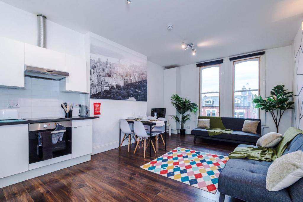 a kitchen and living room with a couch and a table at Spacious City Centre Retreat in Leeds City Centre in Leeds
