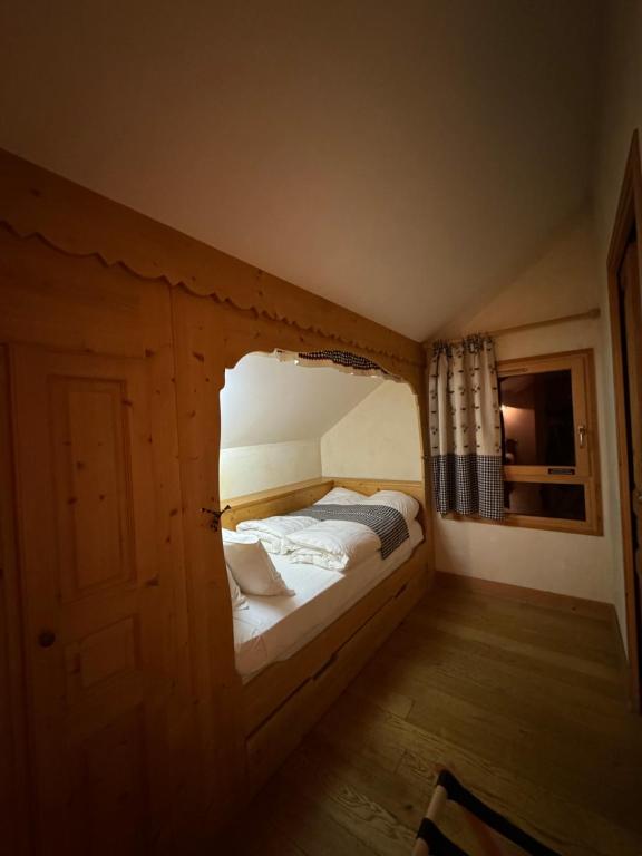 um pequeno quarto com uma cama num quarto em Hôtel le Jalouvre em Mont-Saxonnex