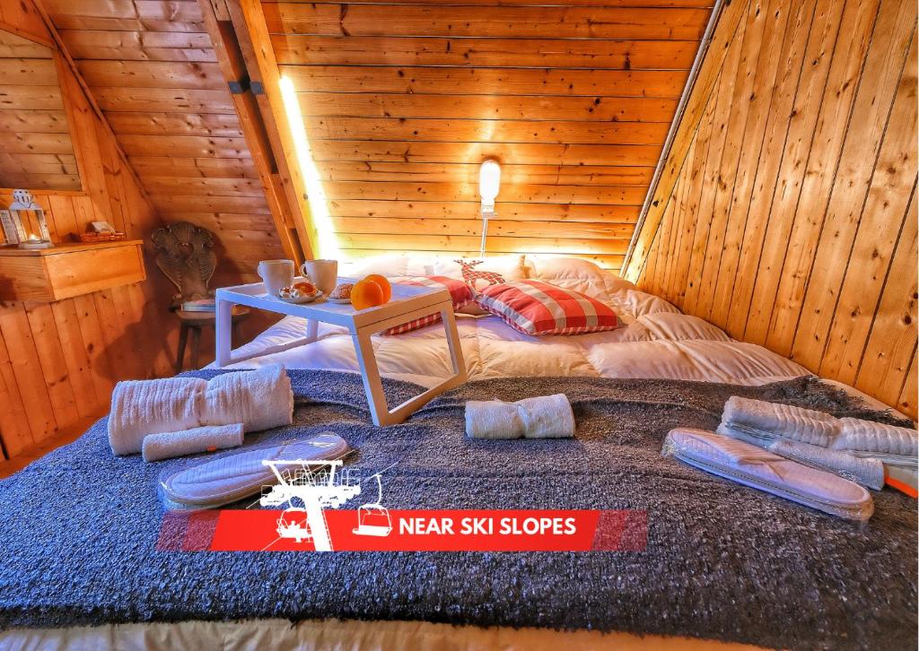 a room with a bed in a wooden cabin at ~Chalet_Rifugio tra i boschi~ in Sella Nevea