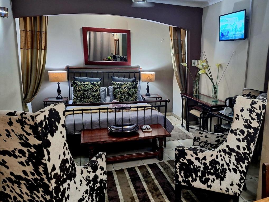 a living room with a couch and two chairs at Garden Apartments in Richards Bay