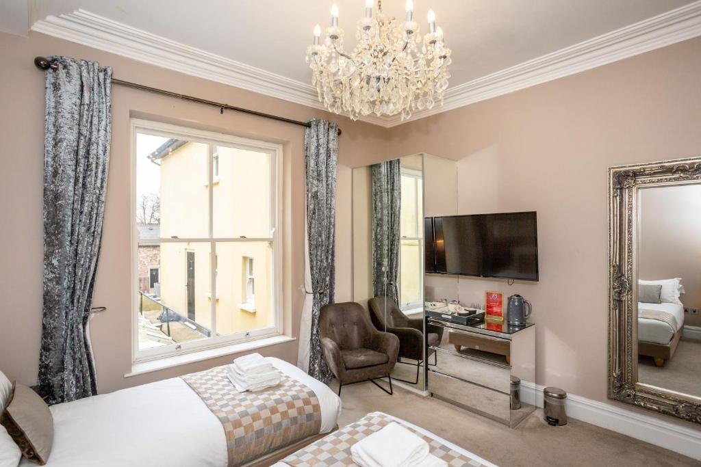 una camera d'albergo con due letti e uno specchio di CoffiCo Hotel a Cardiff