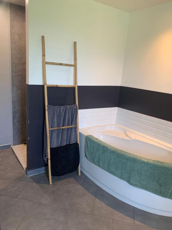 ein Badezimmer mit einer Badewanne und einer Leiter für Handtücher in der Unterkunft Chez Guillaume et ses filles… 