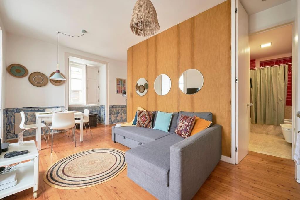 ein Wohnzimmer mit einem Sofa und einem Tisch in der Unterkunft Inglesinhos Convento 1 - Charming Apartment in Lissabon