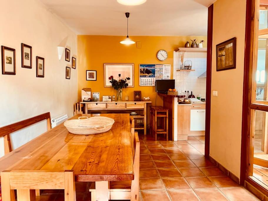 une salle à manger avec une table en bois et une cuisine dans l'établissement CASA RURAL. COVARACINO OJO GUAREÑA, 