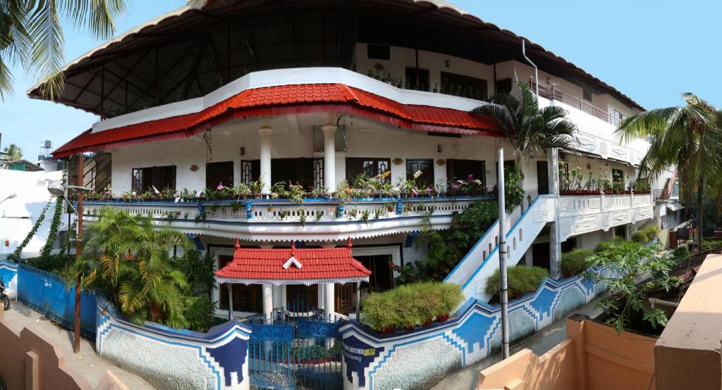 ein Hotelgebäude mit einem roten Dach und einem Balkon in der Unterkunft DreamCatcher Residency in Kochi