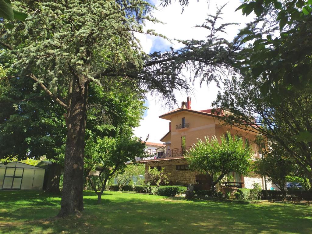 a house with a tree in the yard at Villa Bagno Santo in Sarteano