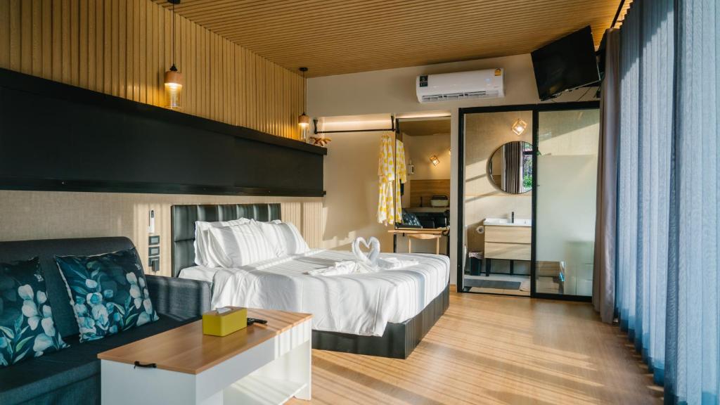 Ban Nong Nok AenにあるNaturalpark Resort De Wangthongのベッドとソファ付きのホテルルーム