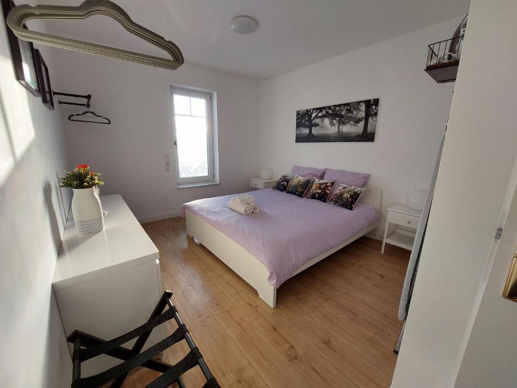 Schlafzimmer mit einem Bett, einem Schreibtisch und einem Fenster in der Unterkunft Villa Bianca - Holiday & Business in Elsenfeld