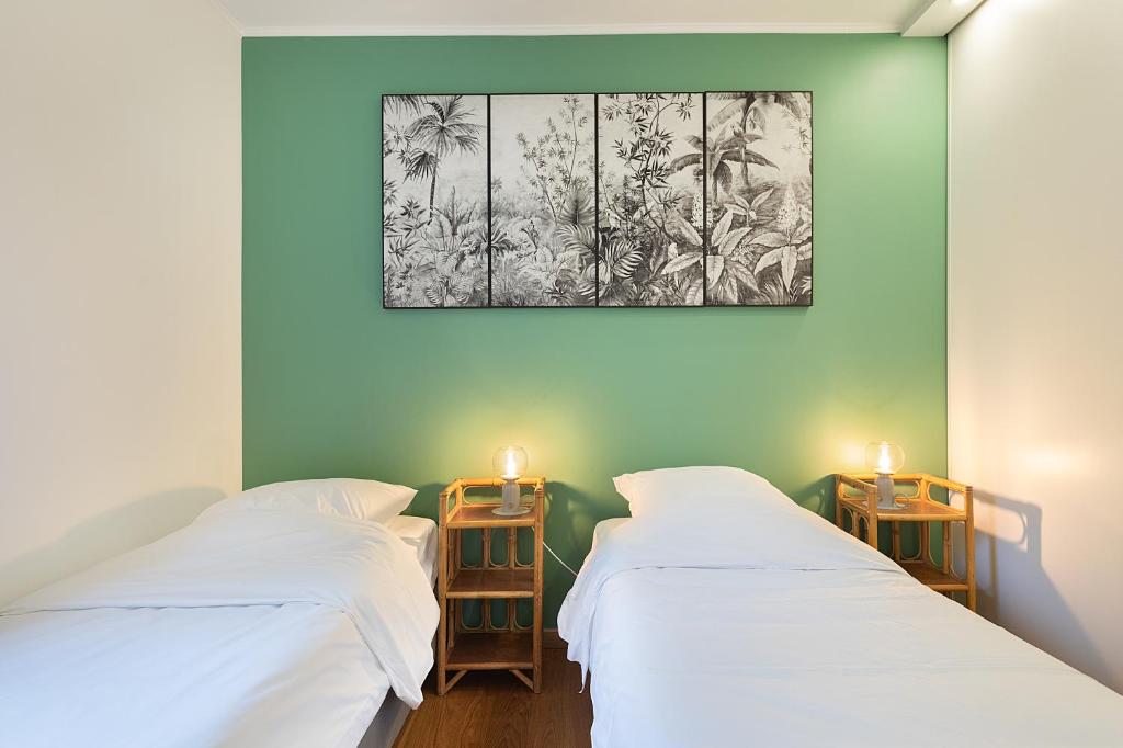 - 2 lits dans une chambre ornée d'une peinture murale dans l'établissement T3 - PARIS 10' Confort & Modern - Terrasse - Parking - WIFI, à Gentilly