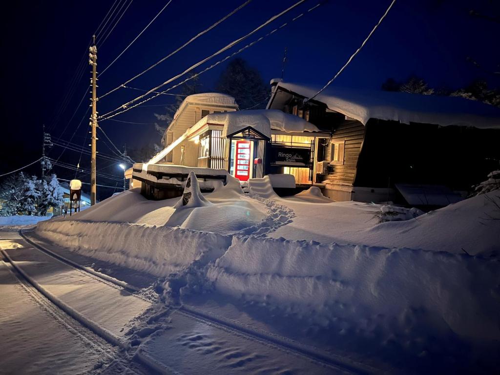 a house is covered in snow at night at Ringo Jam Madarao in Iiyama