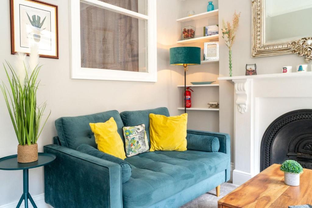 a blue couch in a living room with yellow pillows at Elegant 1Br apartment central Bath in Bath