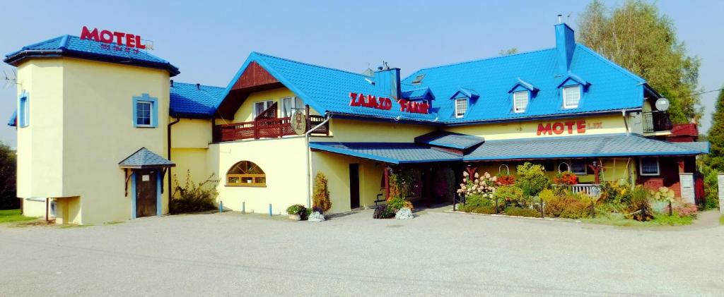 a large building with a blue roof at Zajazd Fakir in Tapkowice