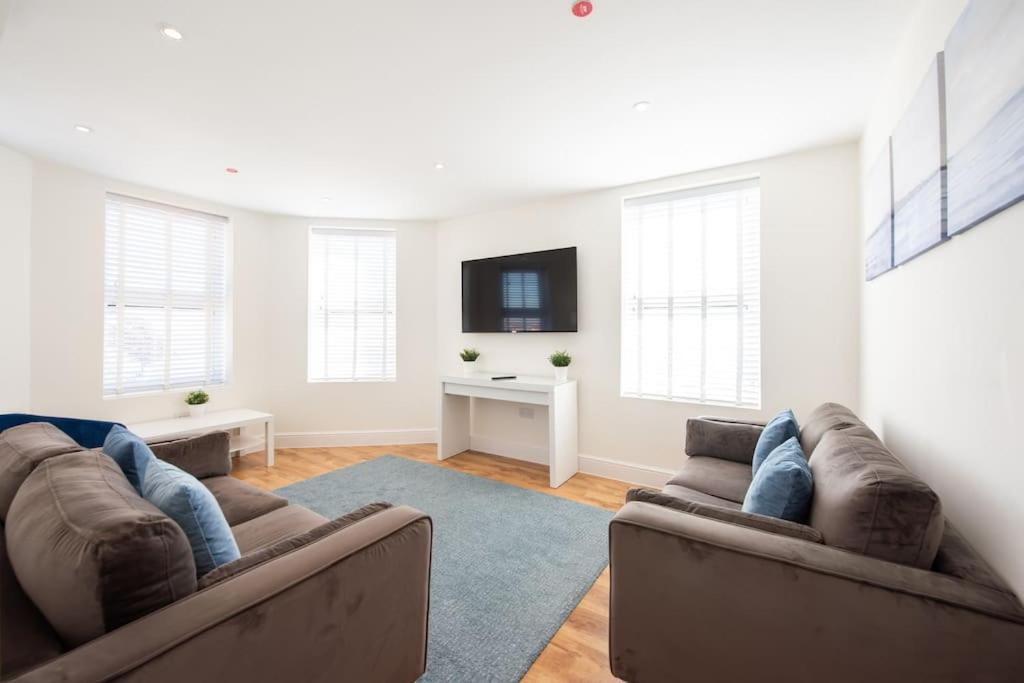 a living room with two brown couches and a tv at Space Apartments - Dovercourt Sea front Duplex Apartment - 1 Bed - Sea Views! in Harwich
