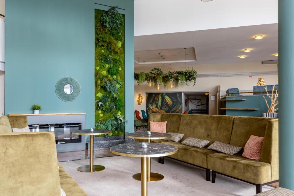 a living room with a couch and tables at Parkhotel Ropeter in Göttingen