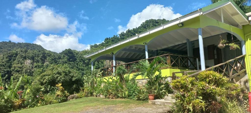 a house on a hill with mountains in the background at Aura Dominica in Roseau