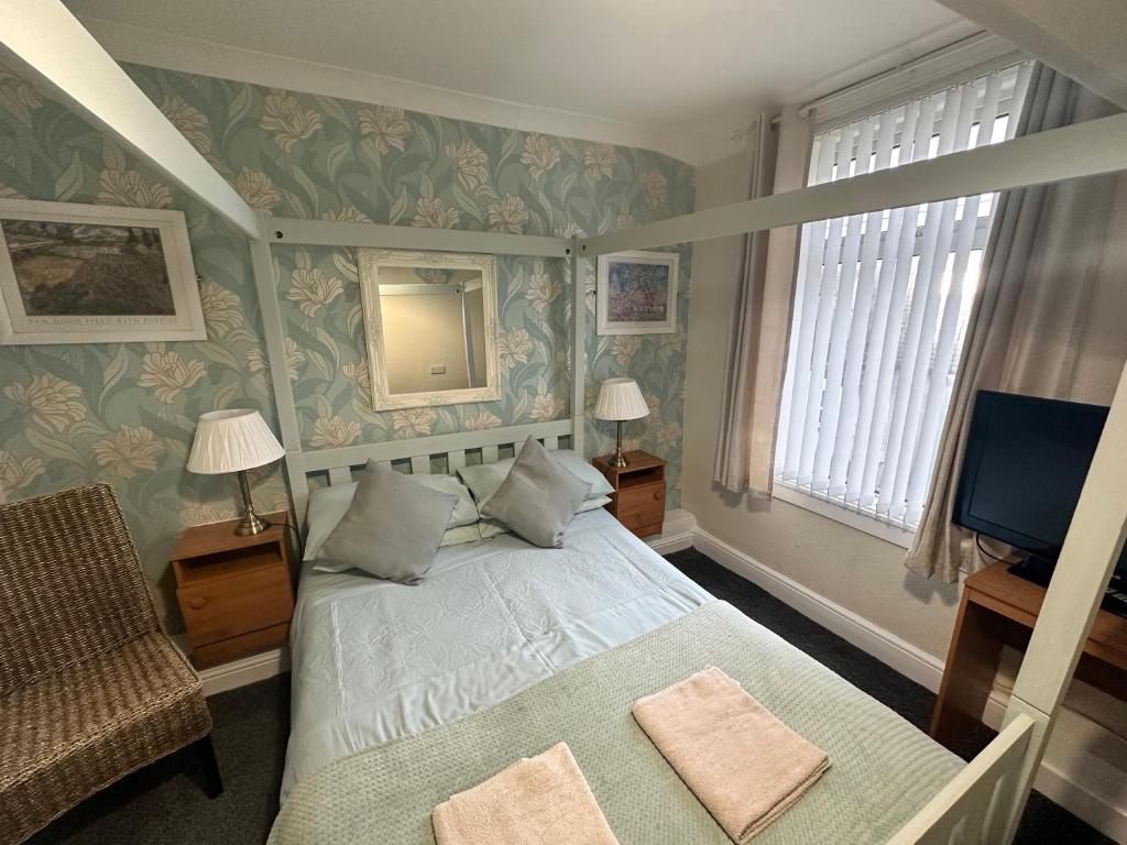 um quarto com uma cama e uma televisão em Greenmount Guest House - Pet Friendly - Central to Everything - Everyone Welcome em Blackpool
