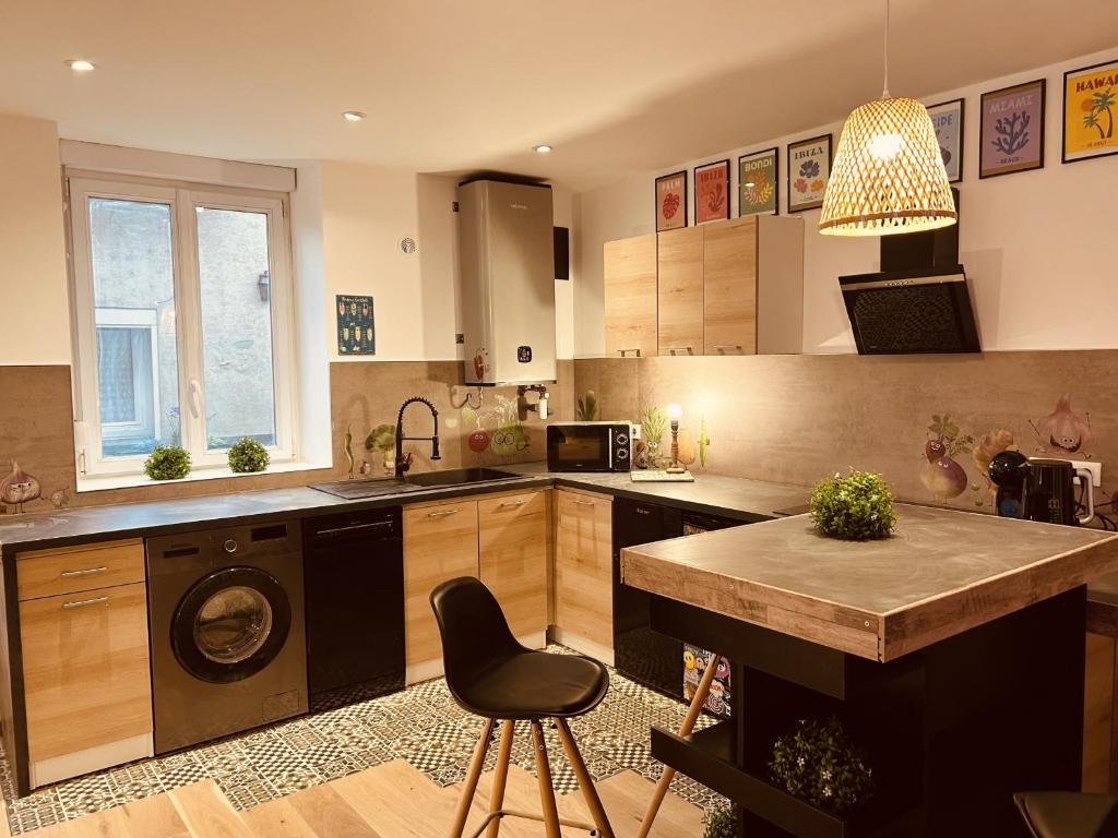a kitchen with a washing machine and a table in it at LA MARIEFACTURE - Comme un Art de Rire in Belleville