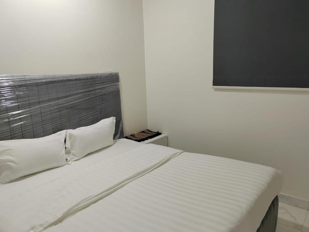 ein weißes Bett mit zwei Kissen in einem Zimmer in der Unterkunft دلتا2للوحدات المخدومة بالدوادمي in Ad-Dawādimi