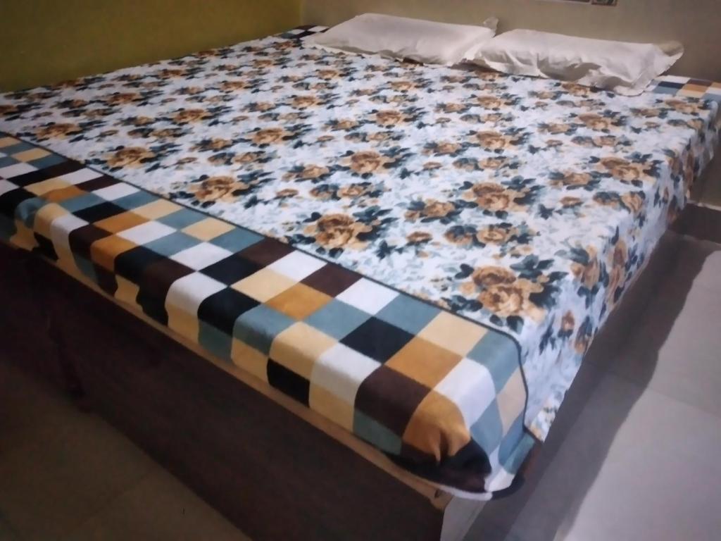 Una cama con una manta encima. en RINGOSTAR PAYING GUEST HOUSE & ROOF TOP RESTAURENT, en Bundi