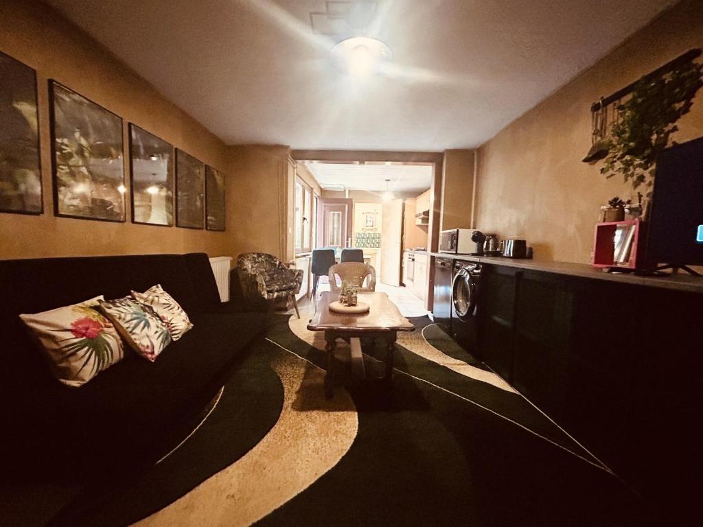 ein Wohnzimmer mit einem Sofa und einem Tisch in der Unterkunft LA MARIEFACTURE - Comme c'est Jungle in Hombourg-Haut