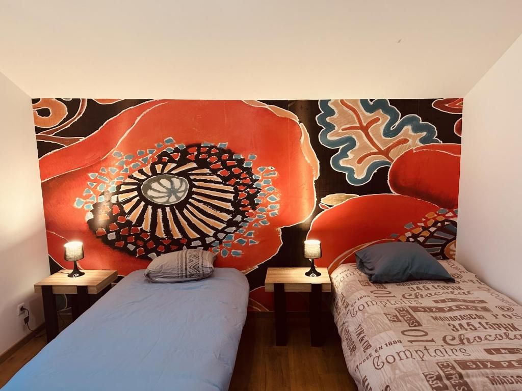 two beds in a room with a painting on the wall at LA MARIEFACTURE - Comme une Fleur 
