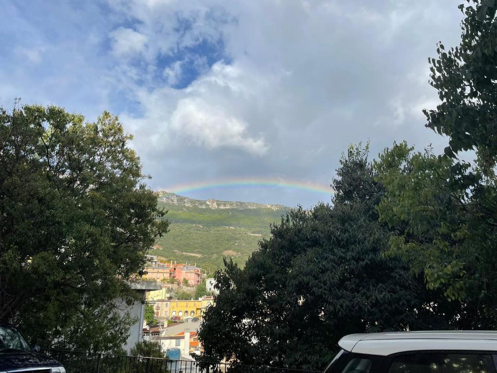 un arco iris en el cielo sobre una ciudad con árboles en Appartamento Su Piricocco - La casa dei ricordi, en Triei