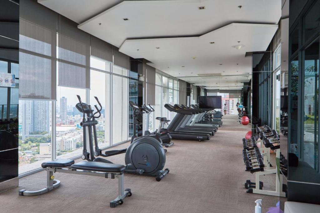 een fitnessruimte met een rij loopbanden en hometrainers bij Sukhumvit 48 BTS Phra khanong 1 Bedroom Apartment, Gym, Swimming pool in Bangkok