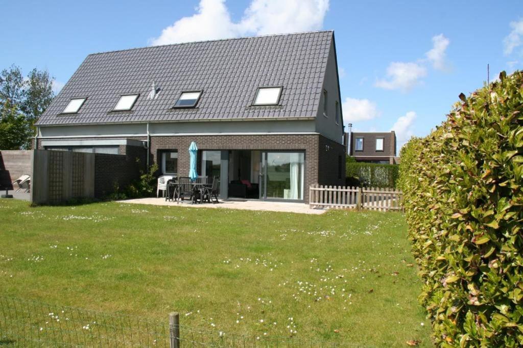 una casa con un gran patio delante de ella en Lamsoor 14*, en Nieuwvliet