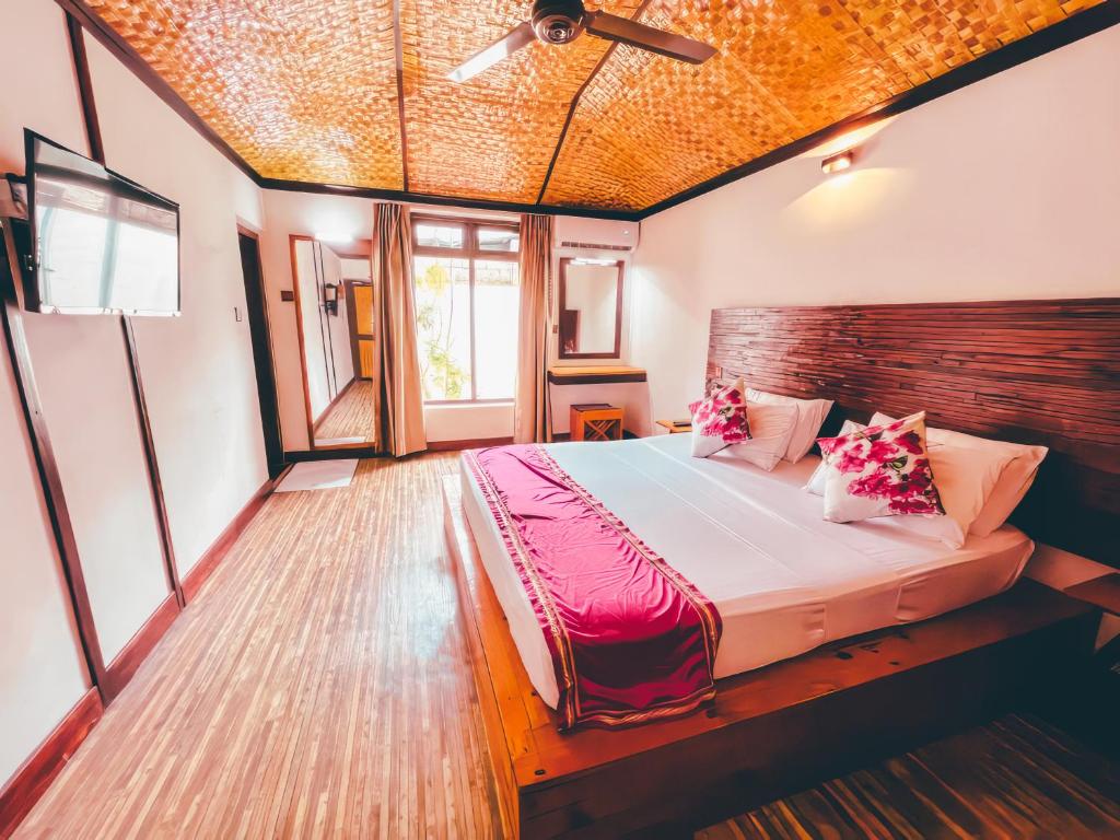 Bougan Villea Retreat في Bodufolhudhoo: غرفة نوم بسرير كبير في غرفة