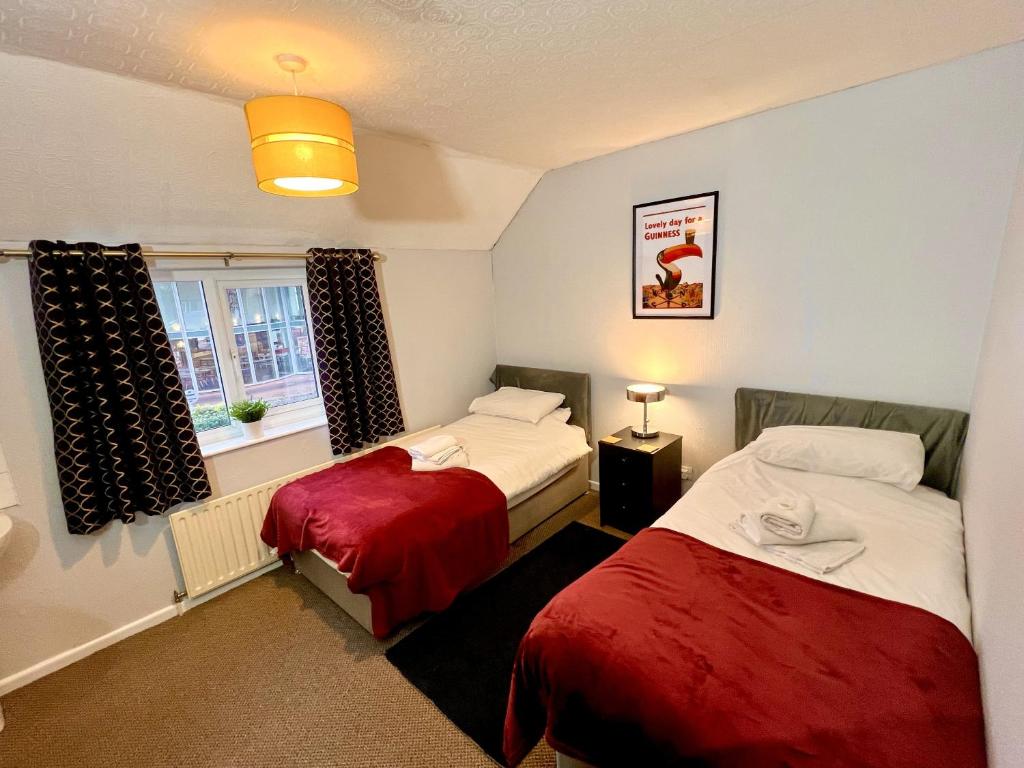a room with two beds and a window at The Horse & Jockey in Gainsborough