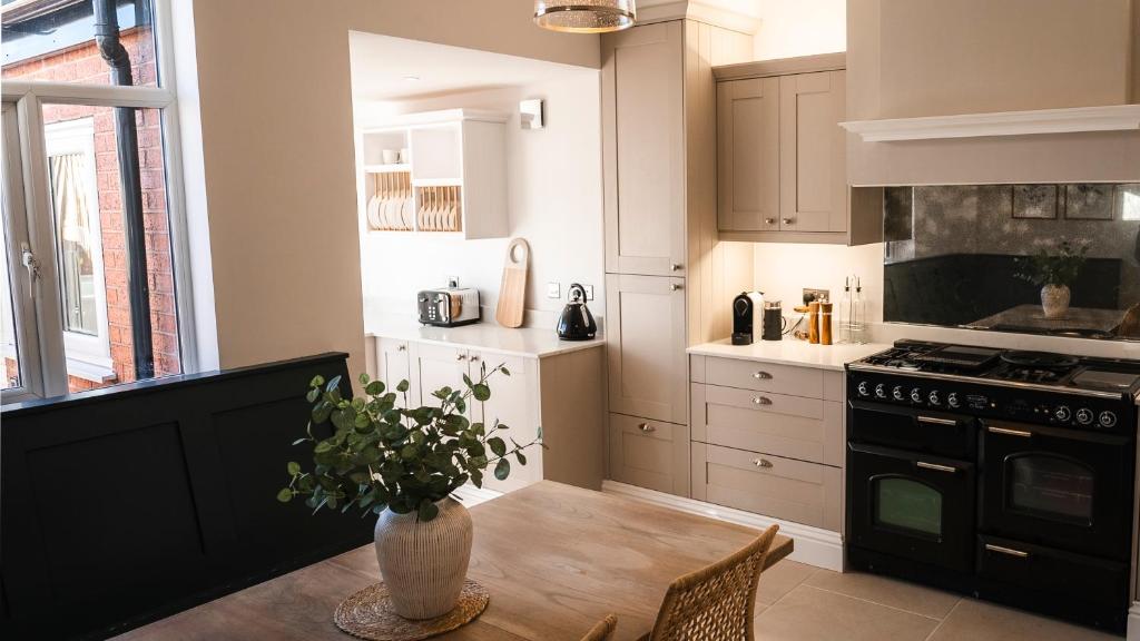 eine Küche mit einem Tisch und einer Vase darauf in der Unterkunft Renovated 3 Bedroom House in Lowton Pennington in Leigh