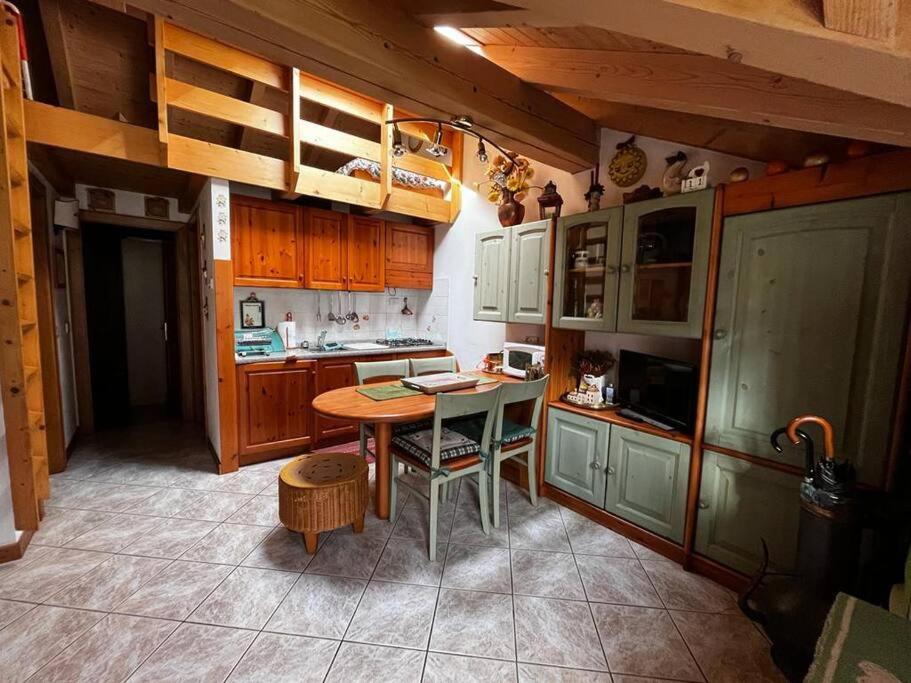 a kitchen with wooden cabinets and a table in it at "Fresia" Cottage Turistico a Fisto in Spiazzo