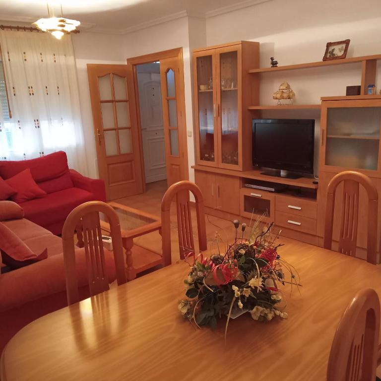 a living room with a table with a couch and a television at Río Adaja in El Fresno