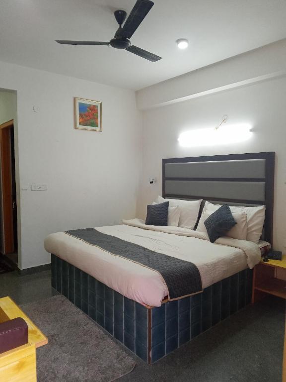 1 dormitorio con 1 cama grande y ventilador de techo en Hotel Grand View en Chail