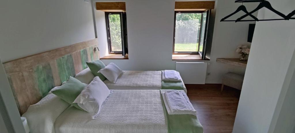 een slaapkamer met 2 bedden en 2 ramen bij Casa Os Prados da Albela in Tríacastela