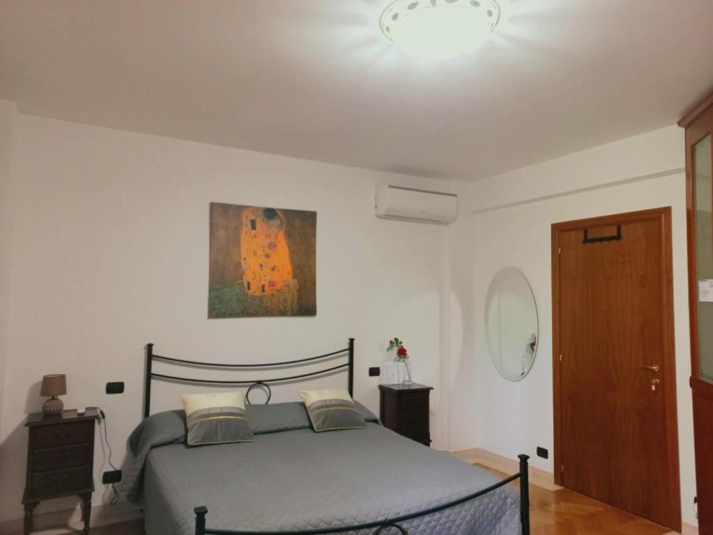 1 dormitorio con 1 cama y una pintura en la pared en B&B ROSE OSIMO en Osimo