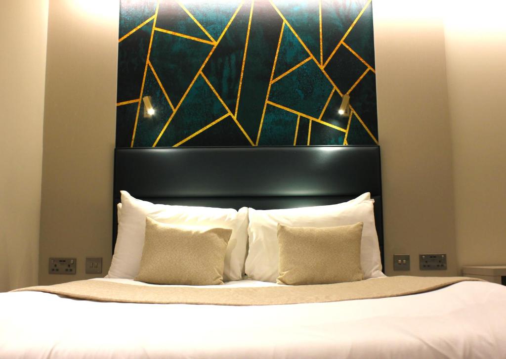 a bed with a black headboard and white pillows at Hendon Studios in The Hyde