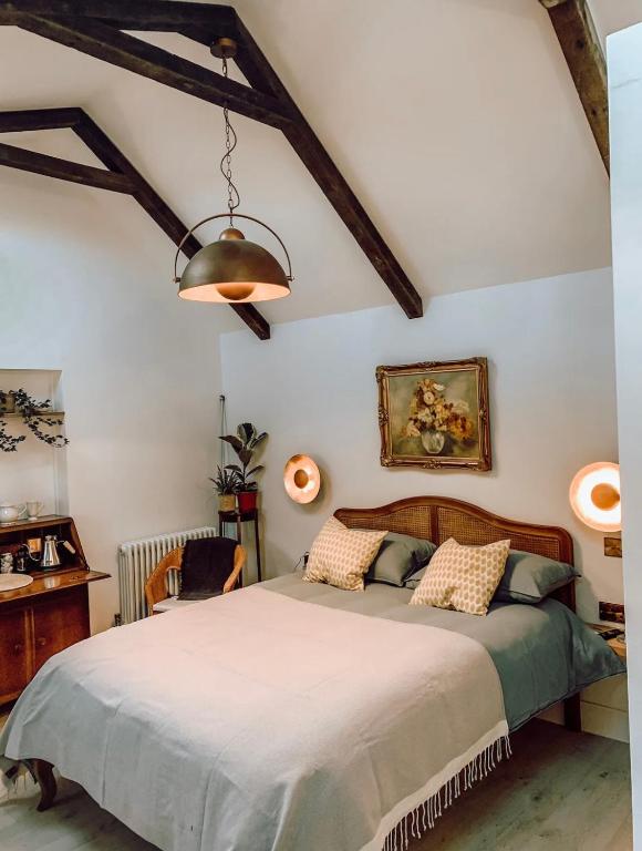 a bedroom with a bed and a lamp and a desk at Priory Cottage in Cowden