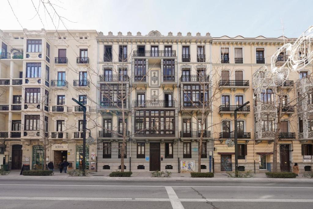 un gran edificio con muchas ventanas en una calle de la ciudad en numa I Vega Apartments, en Granada