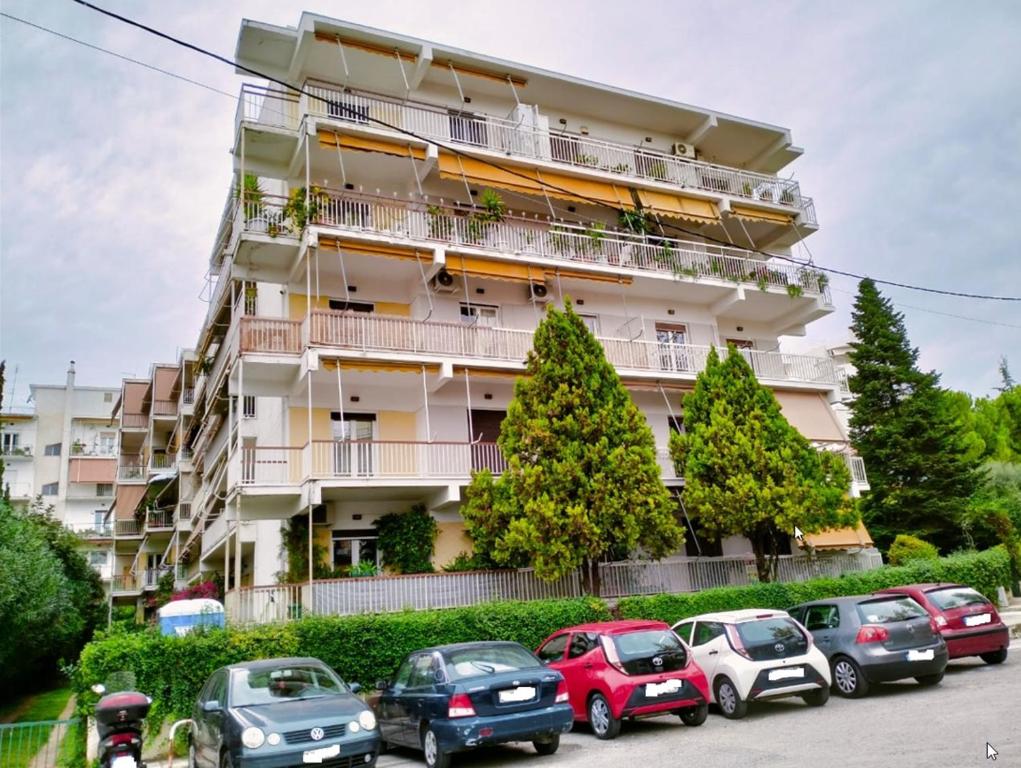un edificio con coches estacionados frente a él en Νέο ανακαινισμένο διαμέρισμα 70τμ στο Μαρούσι, en Atenas