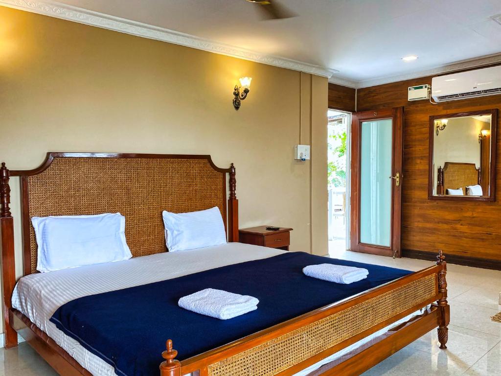 a bedroom with a large bed with two towels on it at Pele's Fisherman Beach Stay in Benaulim