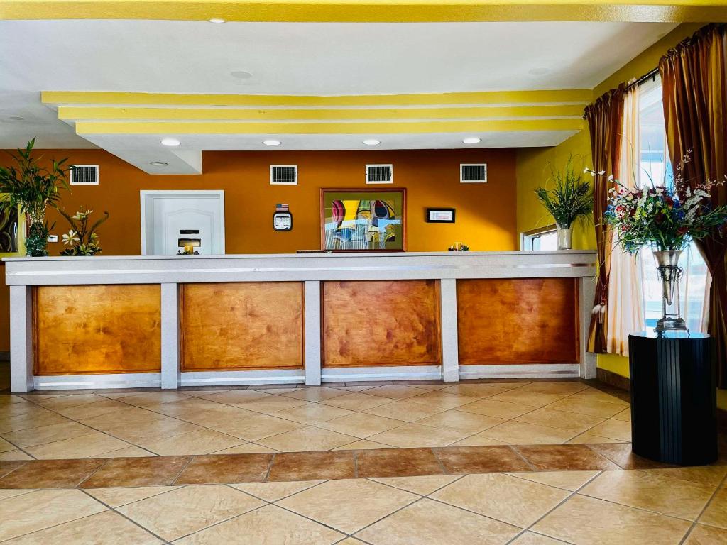 un bar en el vestíbulo del hotel con paredes de color naranja en Econo Lodge Del Rio en Del Río