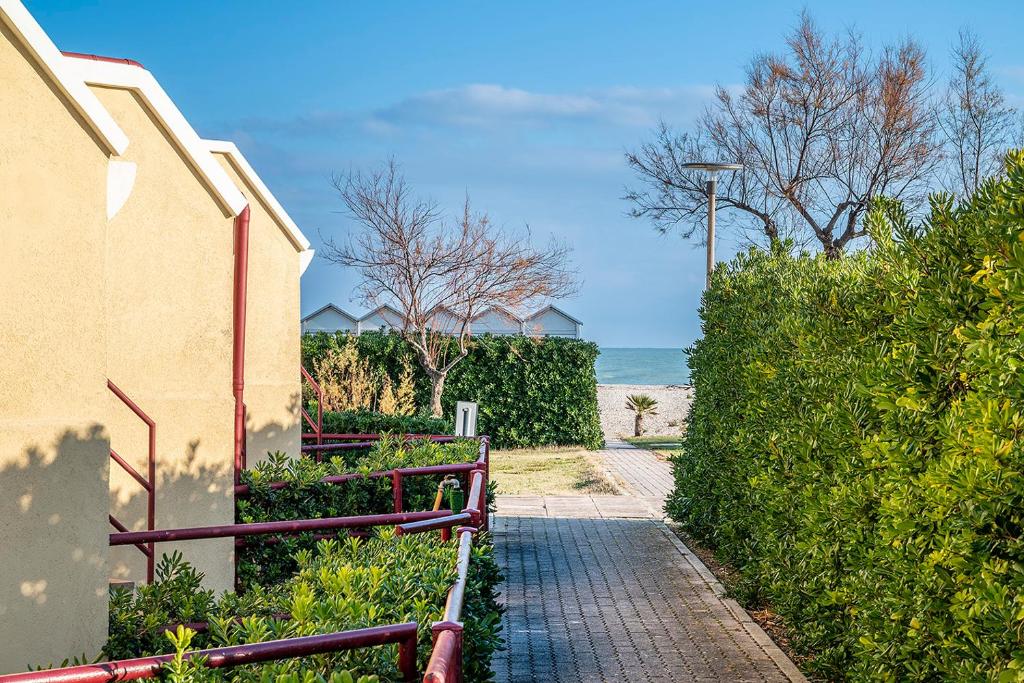 a brick walkway next to a house and the ocean at SE040 - Senigallia, bilocale fronte mare con giardino in Scapezzano