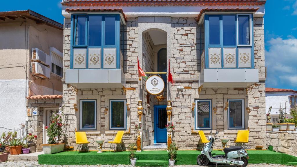 a house with a scooter parked in front of it at Lamur Hotel in Alaçatı