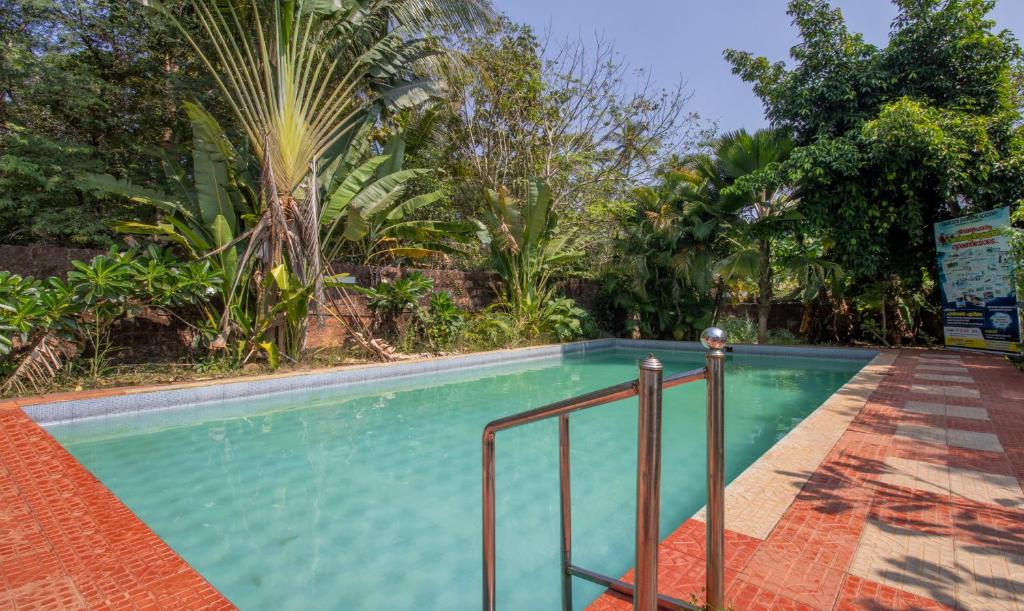 a swimming pool in a resort with trees at Treebo Trend Sadhoo Heritage Ayurvedic Spa & Pool in Kannur