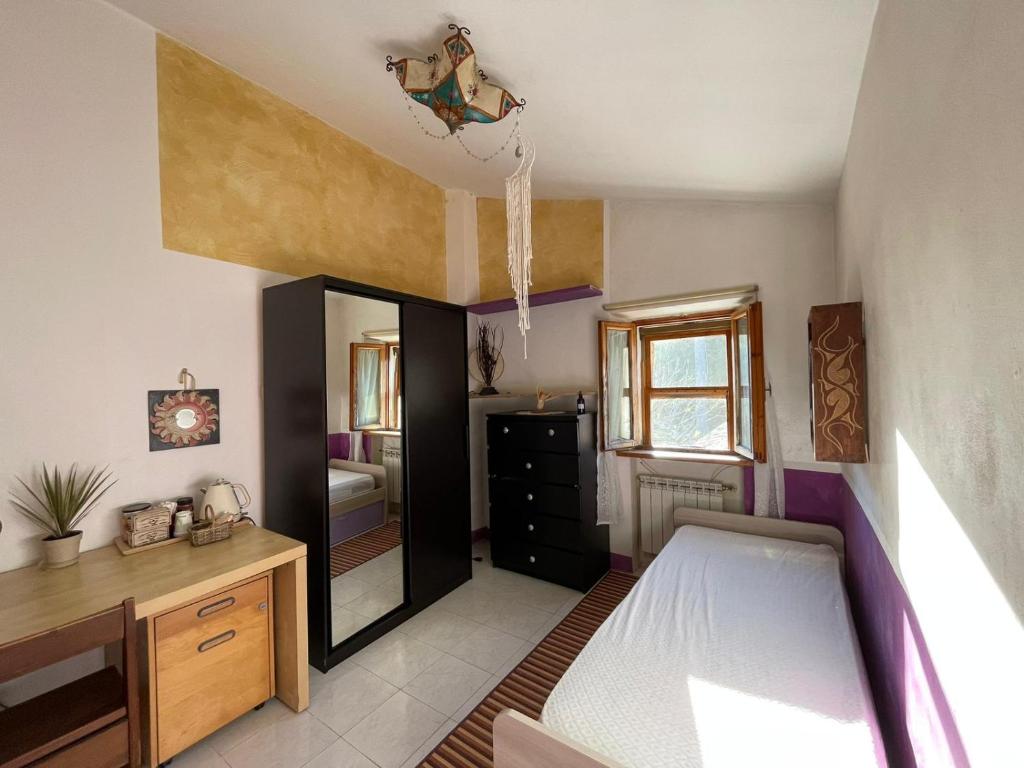 Schlafzimmer mit einem Bett, einem Schreibtisch und einem Spiegel in der Unterkunft Affittacamere la Casella Monteriggioni in Monteriggioni