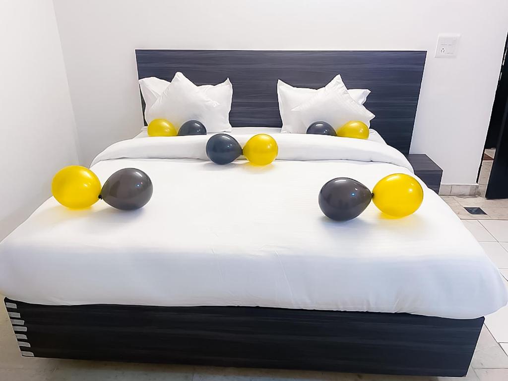 uma cama com balões amarelos e pretos em Stay Saket em Nova Deli
