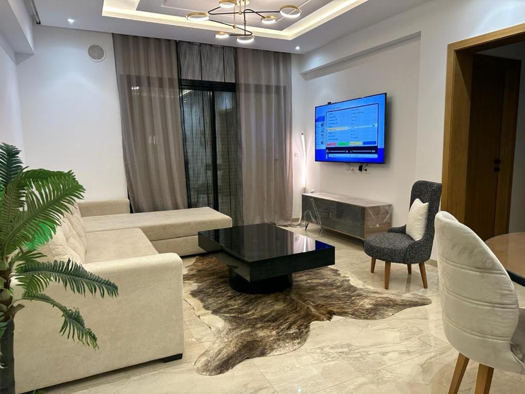 un salon avec un canapé, une table et une télévision dans l'établissement Luxueux S+2 Menzah5, à Ariana